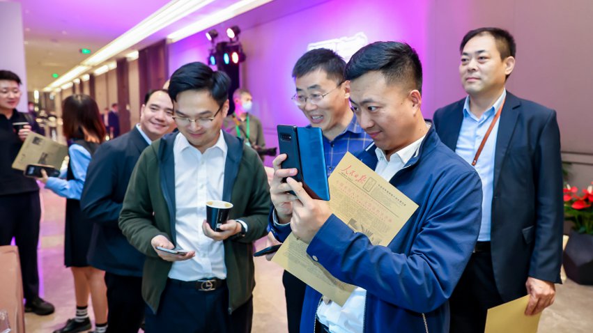 人民網(wǎng)研發(fā)推出的《人民日報(bào)》生日報(bào)吸引嘉賓體驗(yàn)。主辦方供圖