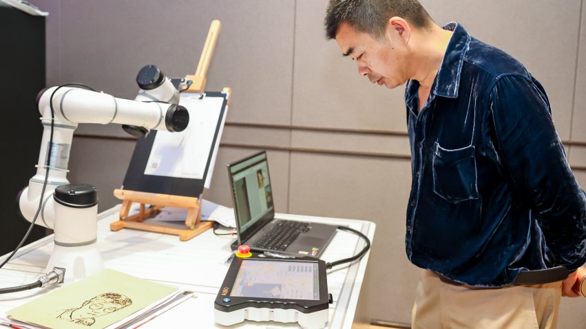 嘉賓體驗(yàn)遨博AI繪畫機(jī)器人。主辦方供圖